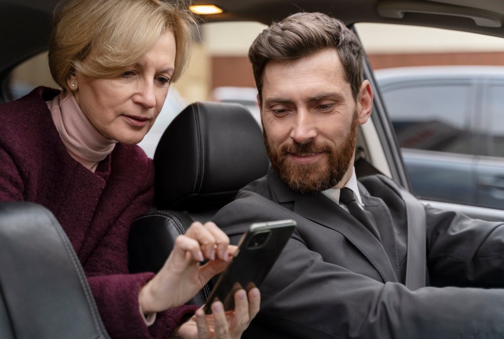 Professional driver assisting a passenger in a car